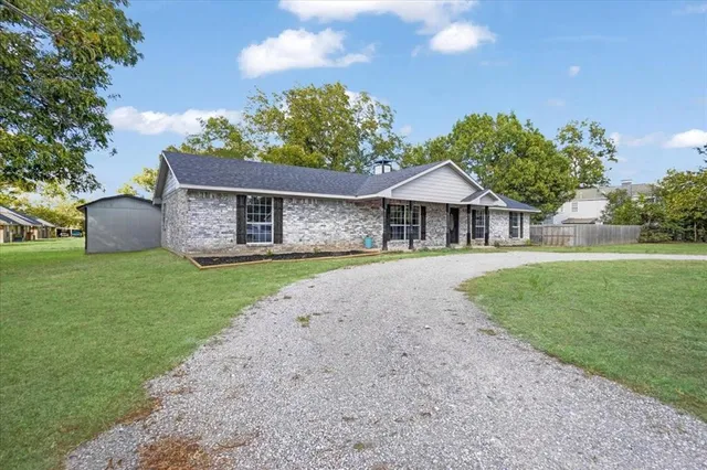 a front view of a house with a garden and yard
