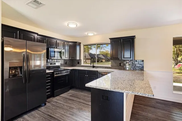 a kitchen with granite countertop stainless steel appliances and wooden cabinets