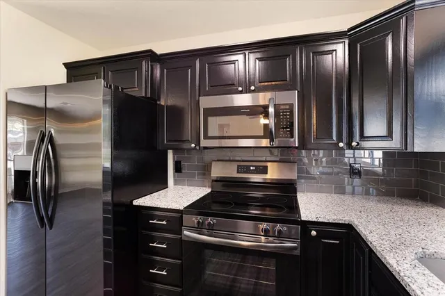 a kitchen with granite countertop stainless steel appliances and wooden cabinets