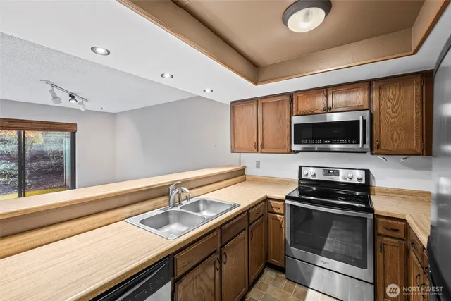 a kitchen with a sink stainless steel appliances and cabinets