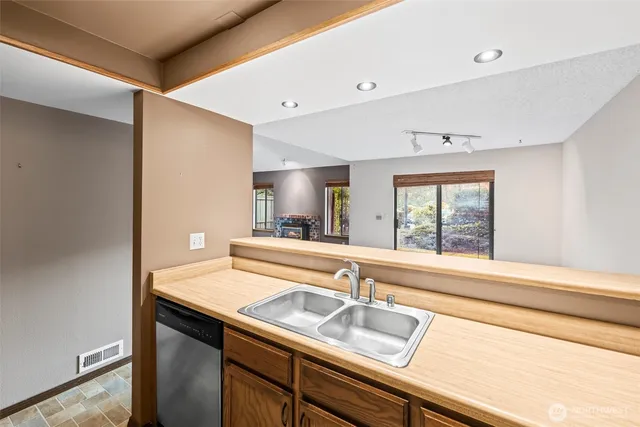 a white kitchen with sink and window