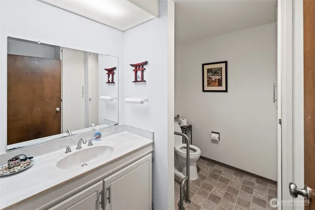 a bathroom with a sink and mirror with toilet