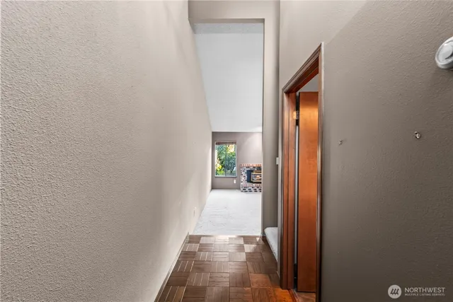 a view of a hallway with wooden floor and a bathroom