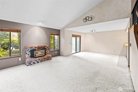 a view of an empty room with a fireplace and a window