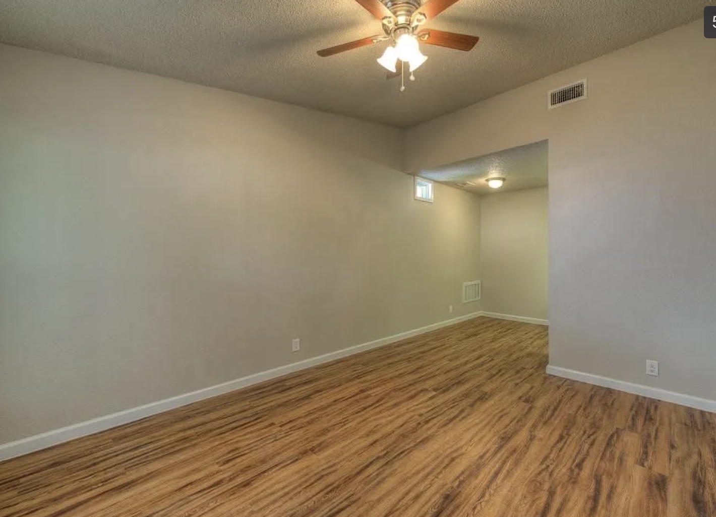 1124 Gardner Road, Unit B Austin, TX 78721 - Photo 7 of 15 Empty room featuring a textured ceiling, wood finished floors, and a ceiling fan