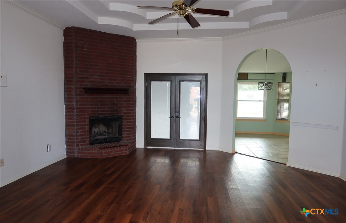 5101 Spring Drive Killeen, TX 76542 - Photo 3 of 11 an empty room with wooden floor a fireplace and windows