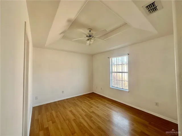 an empty room with windows and fan