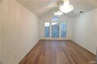 an empty room with wooden floor and mirror