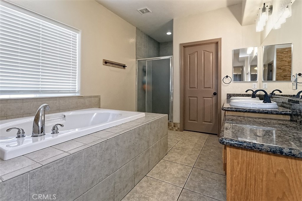 8855 Smith Road Phelan, CA 92371 - Photo 28 of 43 a spacious bathroom with a tub sink and mirror
