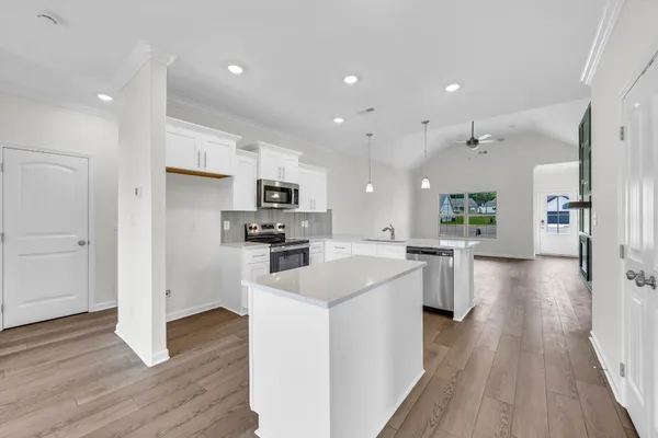 a kitchen with white cabinets and stainless steel appliances