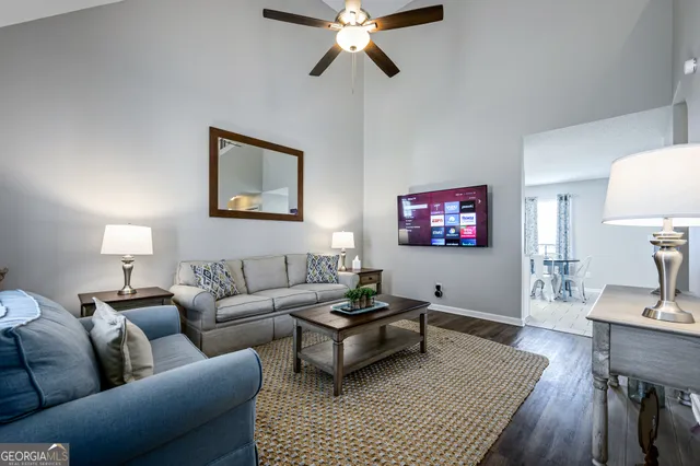 a living room with furniture a rug and a lamp