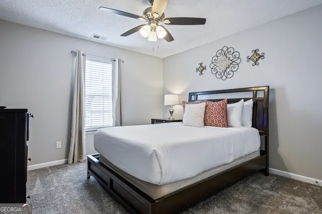 a large bed sitting in a bedroom next to a window and a chandelier