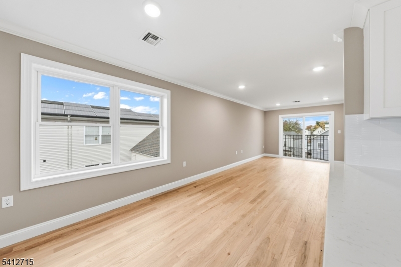 840 Martin Street Elizabeth, NJ 07201 - Photo 6 of 38 a view of an empty room with a window and wooden floor
