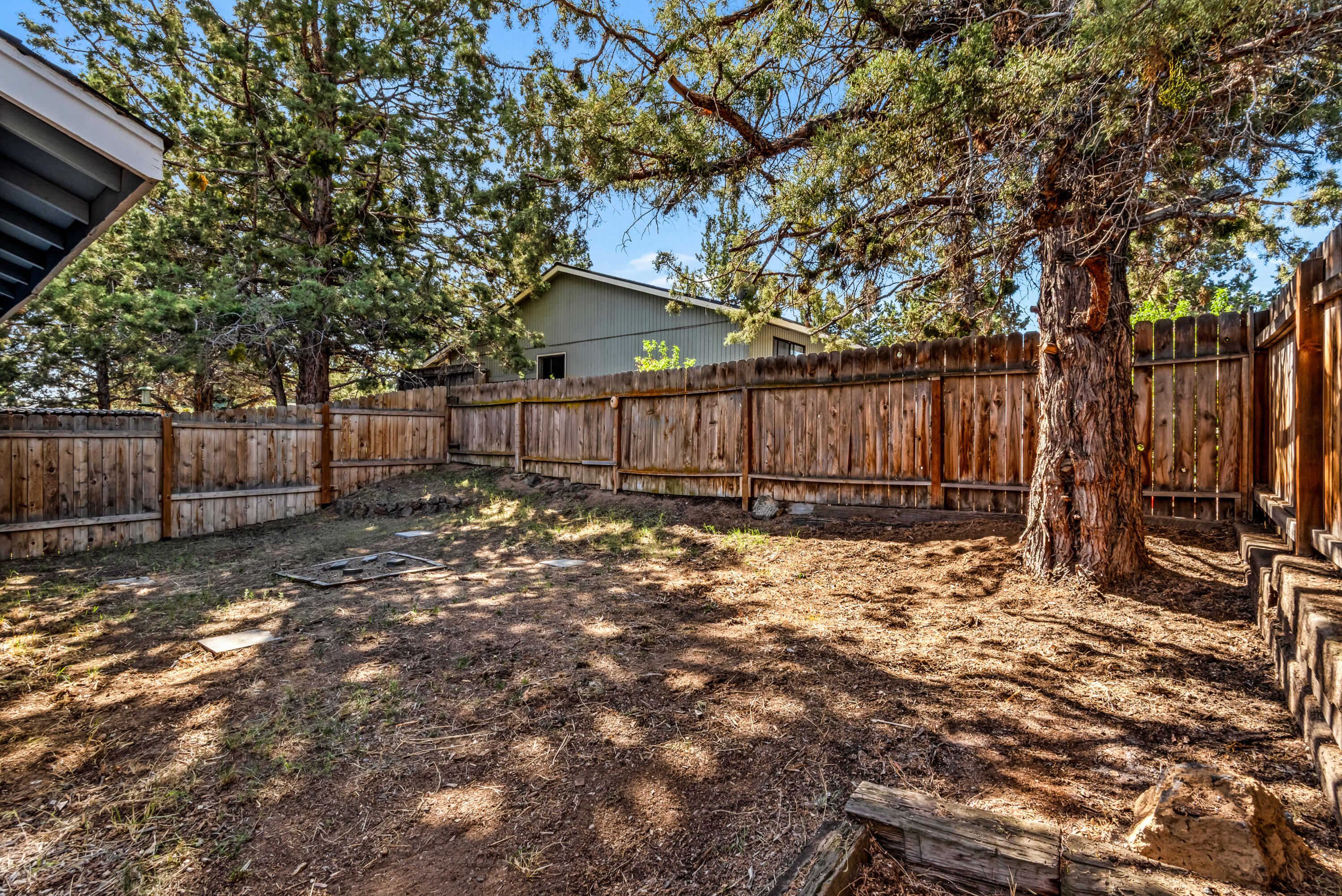 1916 Northeast Wichita Way Bend, OR 97701 - Photo 17 of 38 a view of backyard with wooden fence and large trees