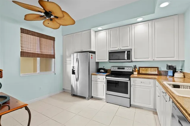 a kitchen with stainless steel appliances granite countertop a refrigerator a stove top oven a sink and dishwasher