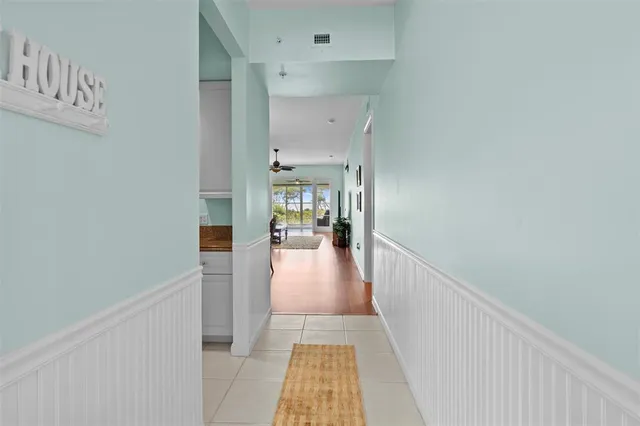 a view of a hallway with wooden floor and a living room