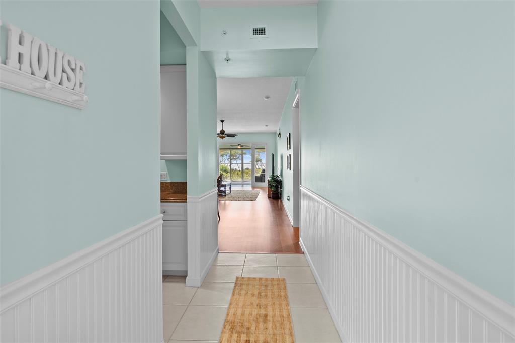 23 Harbour Isle Drive West, Unit 102 Fort Pierce, FL 34949 - Photo 16 of 40 a view of a hallway with wooden floor and a living room