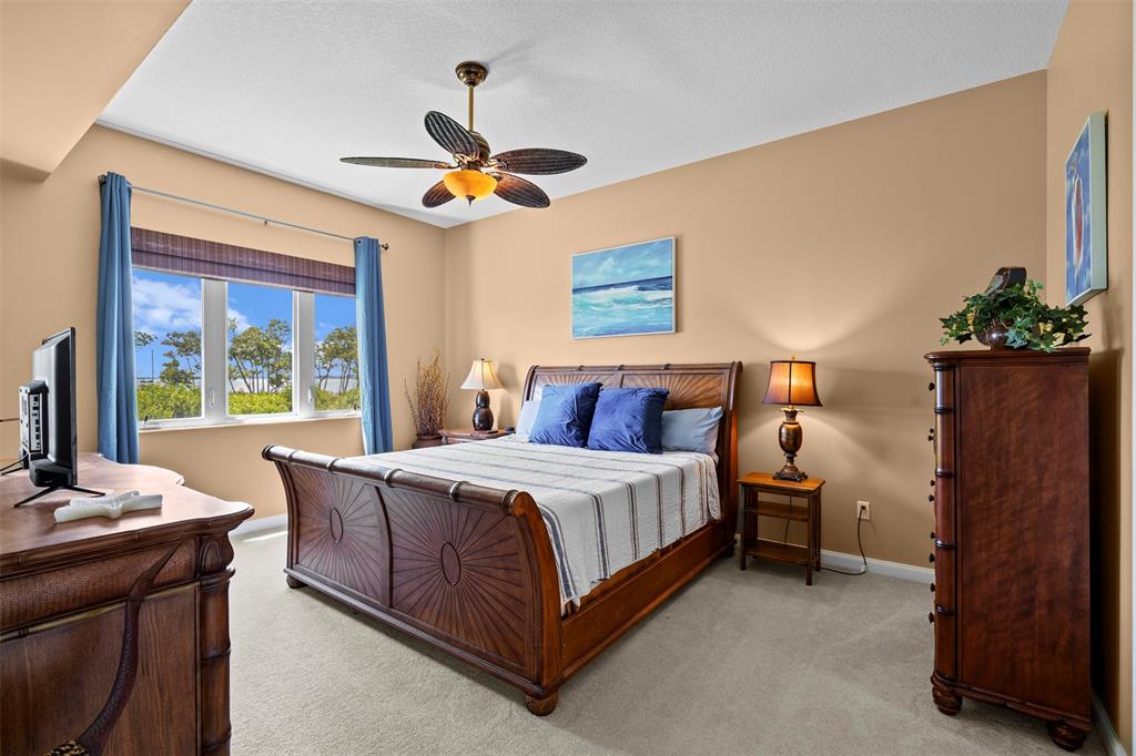 23 Harbour Isle Drive West, Unit 102 Fort Pierce, FL 34949 - Photo 17 of 40 a bed room with a bed and a chandelier