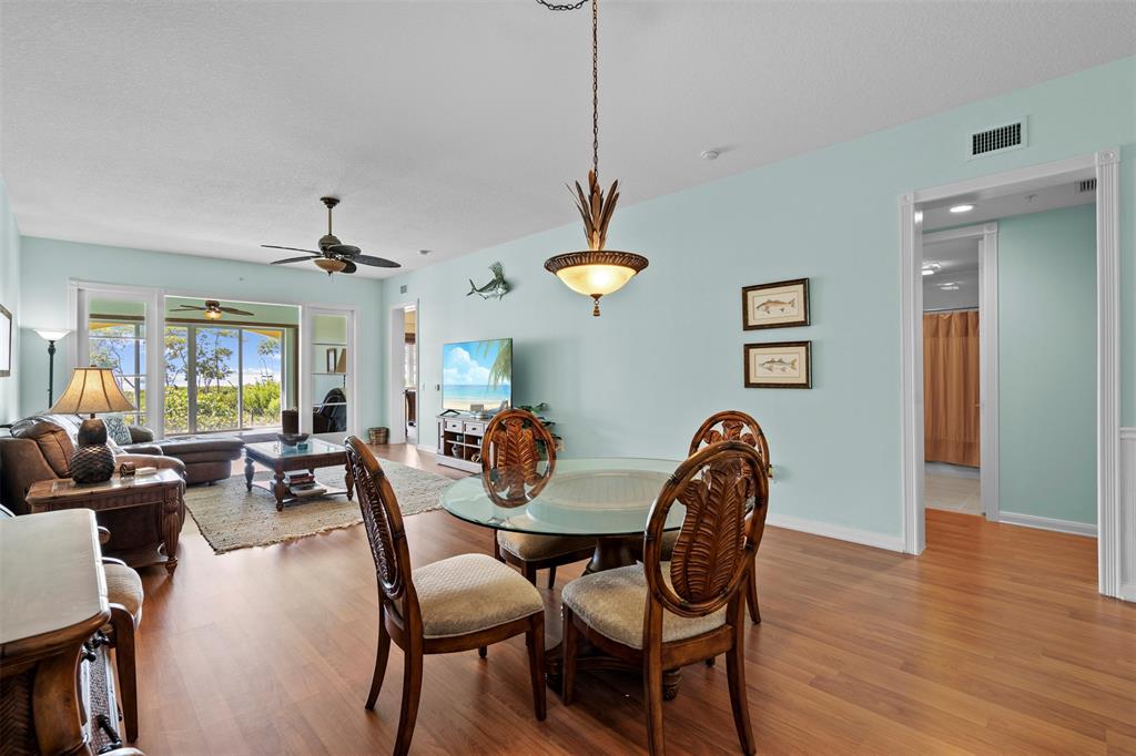 23 Harbour Isle Drive West, Unit 102 Fort Pierce, FL 34949 - Photo 6 of 40 a dining room with wooden floor a chandelier a glass table and chairs