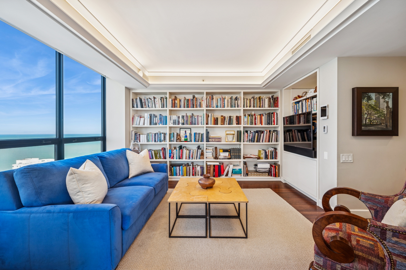180 East Pearson Street, Unit 3701 Chicago, IL 60611 - Photo 17 of 36 a living room with furniture and a bookshelf
