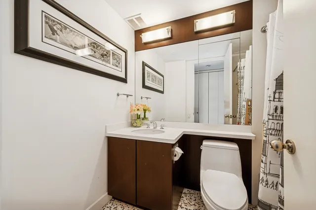 a bathroom with a sink a toilet and mirror