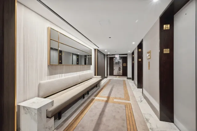 a hallway with wooden floor stairs and furniture