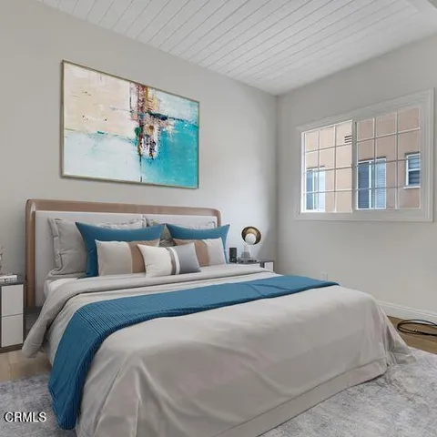 a bedroom with bed painting on the wall and a window