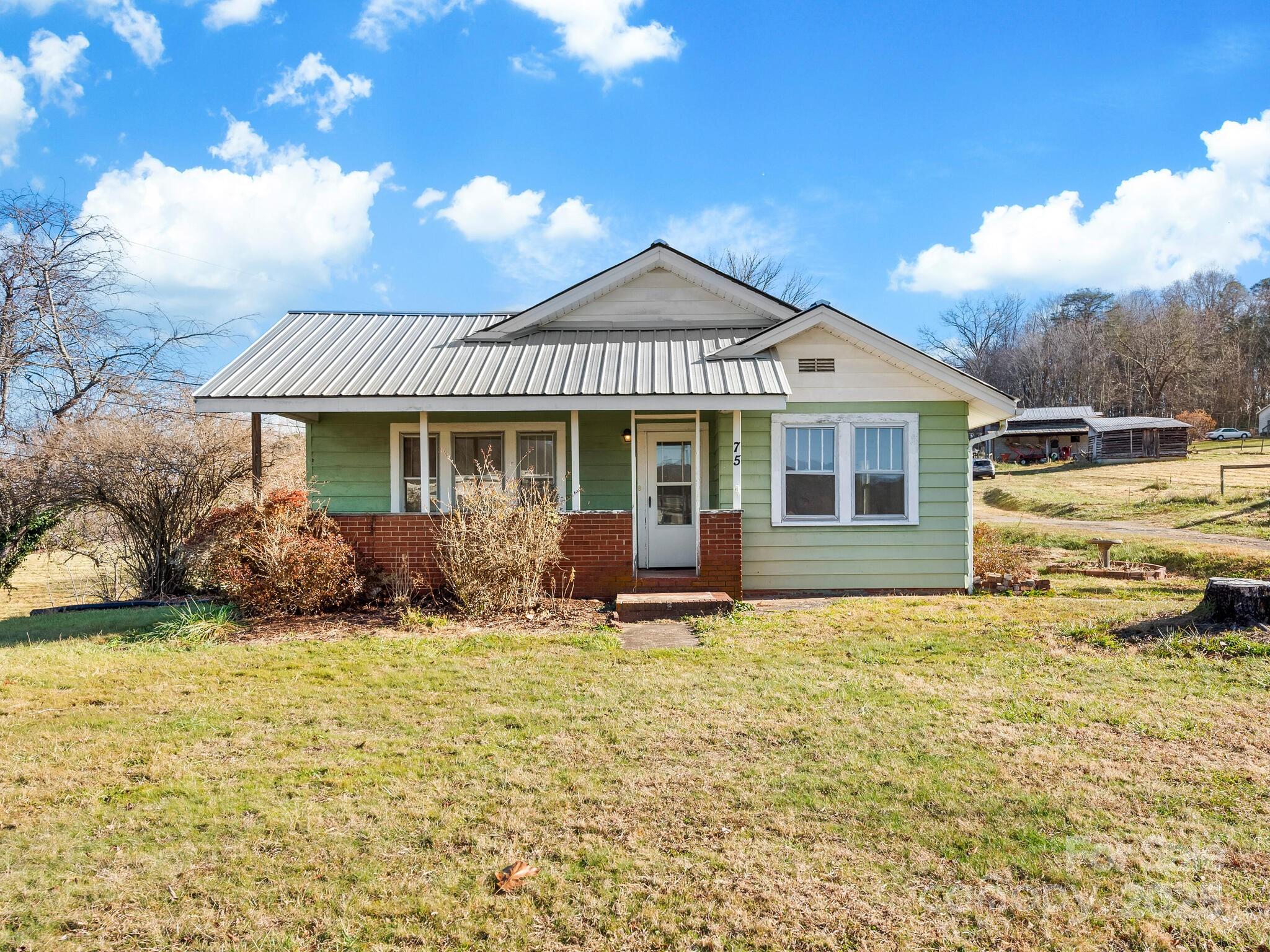 71 Lower Glady Fork Road Candler, NC 28715 - Photo 5 of 43 a front view of a house with a garden and yard