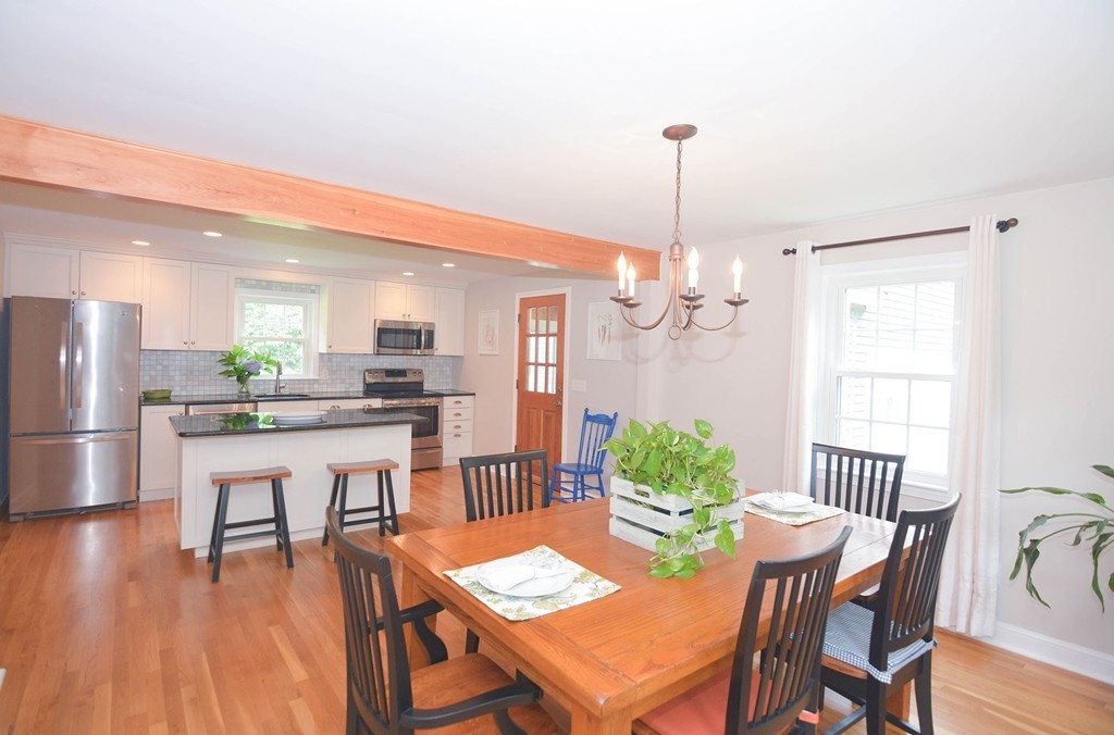 503 Lowell Road Groton, MA 01450 - Photo 6 of 18 a dining room with furniture a chandelier and wooden floor