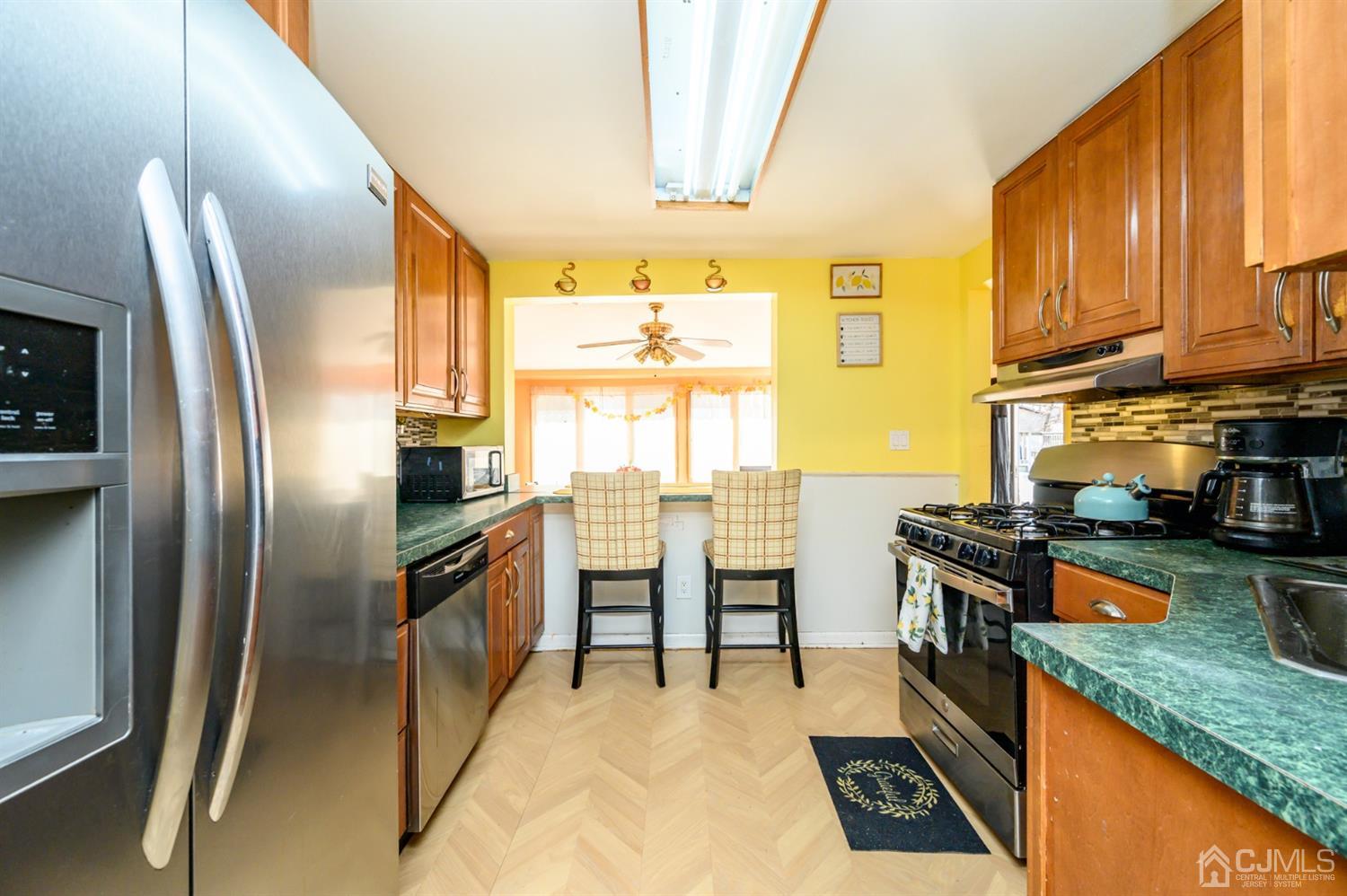 69 Bergerville Road Freehold, NJ 07728 - Photo 5 of 28 a kitchen with stainless steel appliances granite countertop a sink a stove and a refrigerator