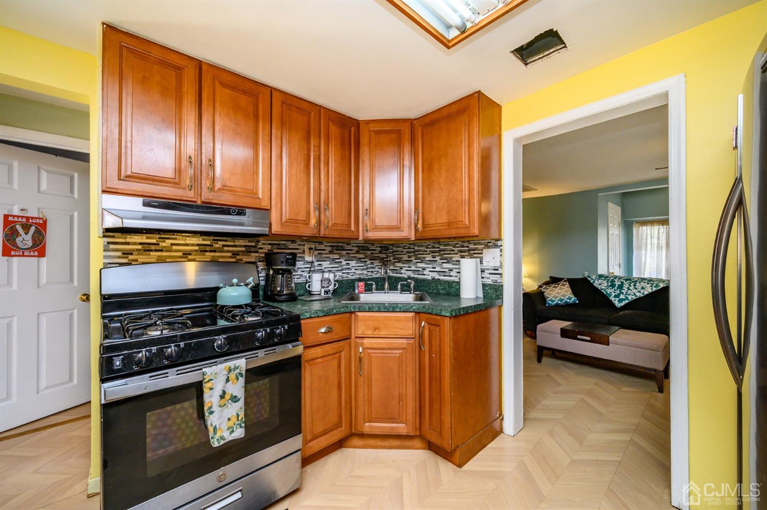 69 Bergerville Road Freehold, NJ 07728 - Photo 6 of 28 a kitchen with stainless steel appliances a stove a sink and cabinets