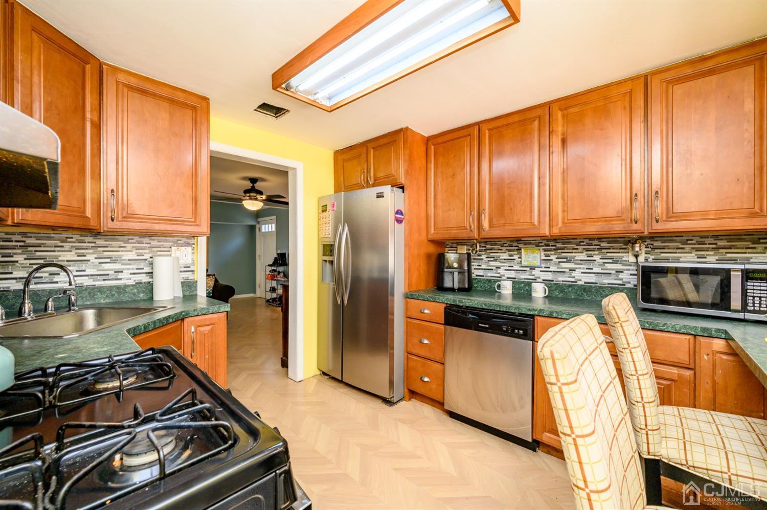 69 Bergerville Road Freehold, NJ 07728 - Photo 7 of 28 a kitchen with stainless steel appliances granite countertop a refrigerator and a stove top oven