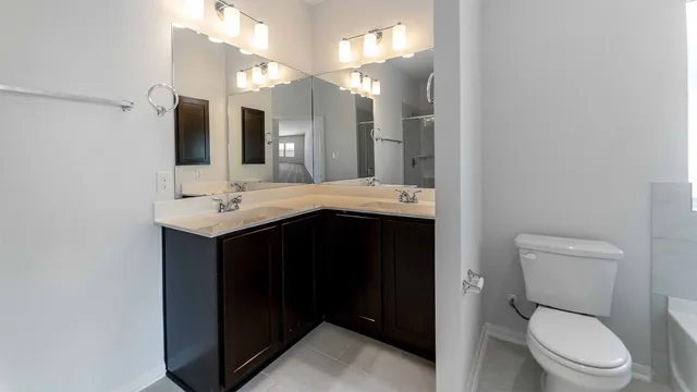 a bathroom with a granite countertop sink toilet and mirror