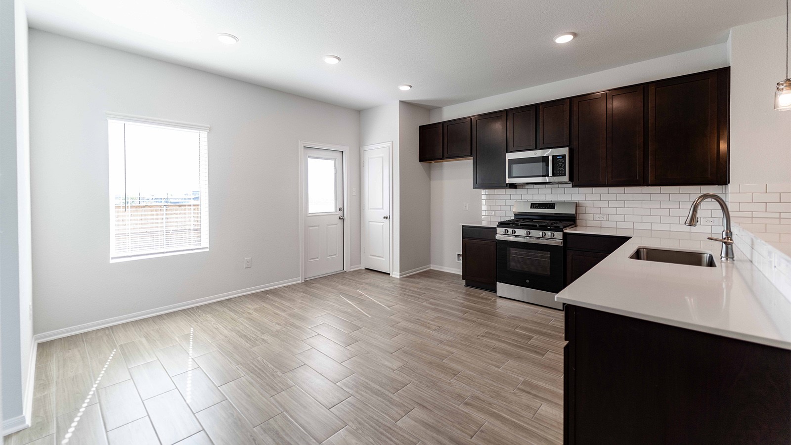 13605 Endless Narrow Lane Elgin, TX 78621 - Photo 5 of 16 a kitchen with stainless steel appliances a microwave sink refrigerator and cabinets