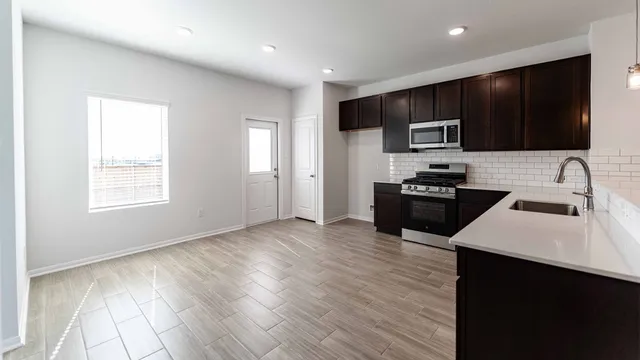 a kitchen with stainless steel appliances a microwave sink refrigerator and cabinets