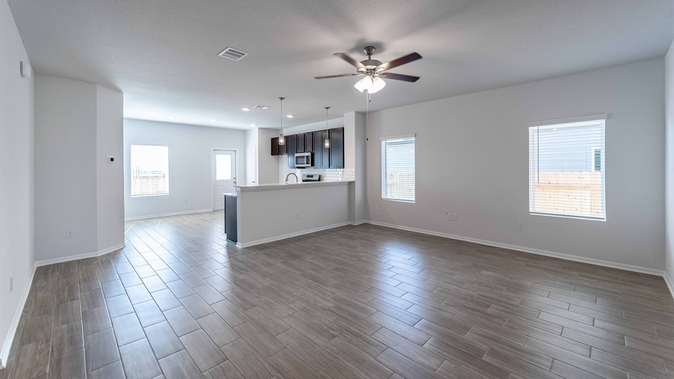 13605 Endless Narrow Lane Elgin, TX 78621 - Photo 9 of 16 a view of a livingroom with wooden floor and a kitchen