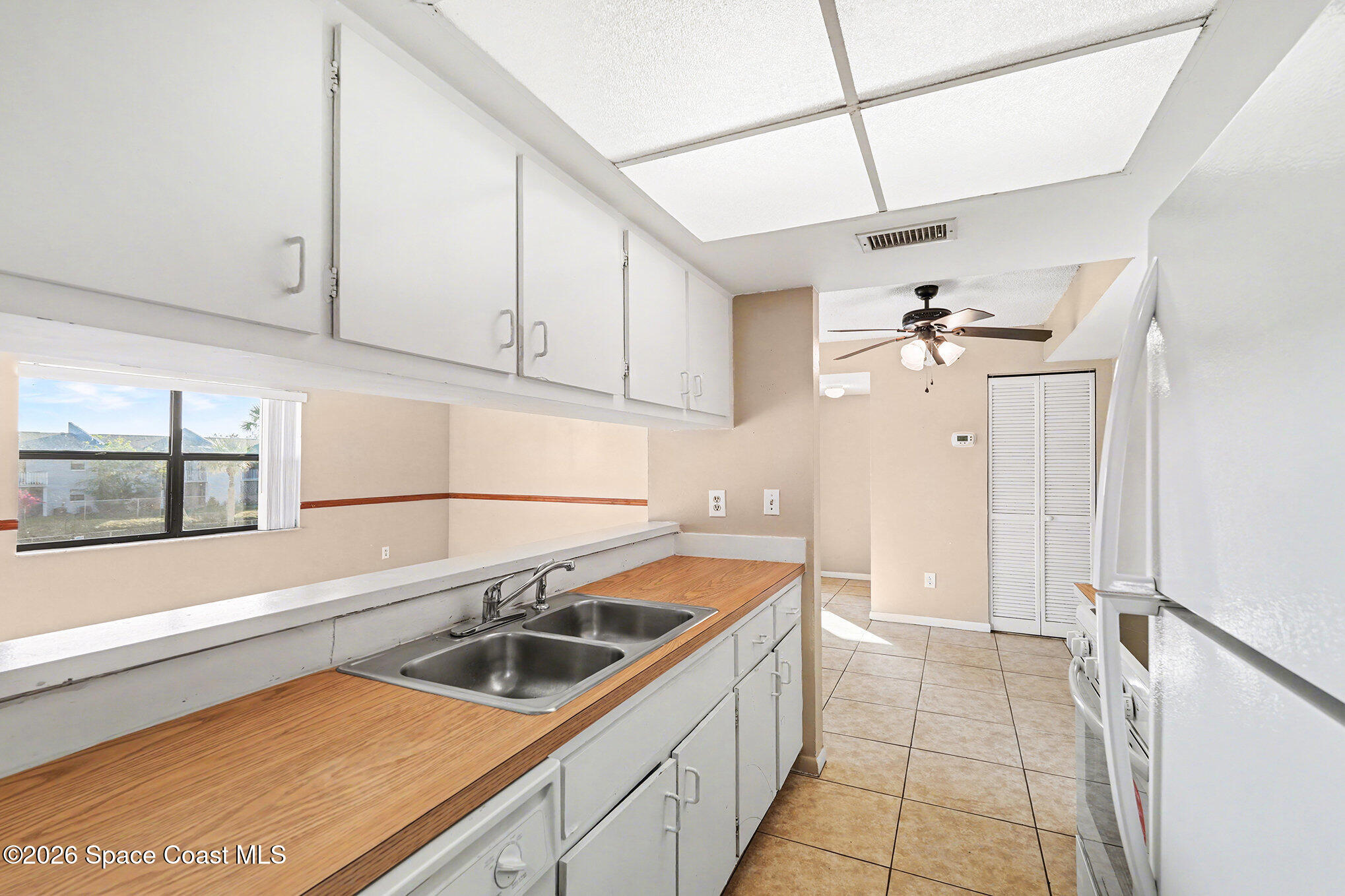 598 North Wickham Road, Unit 74 Melbourne, FL 32935 - Photo 6 of 13 a kitchen with a sink a refrigerator and cabinets