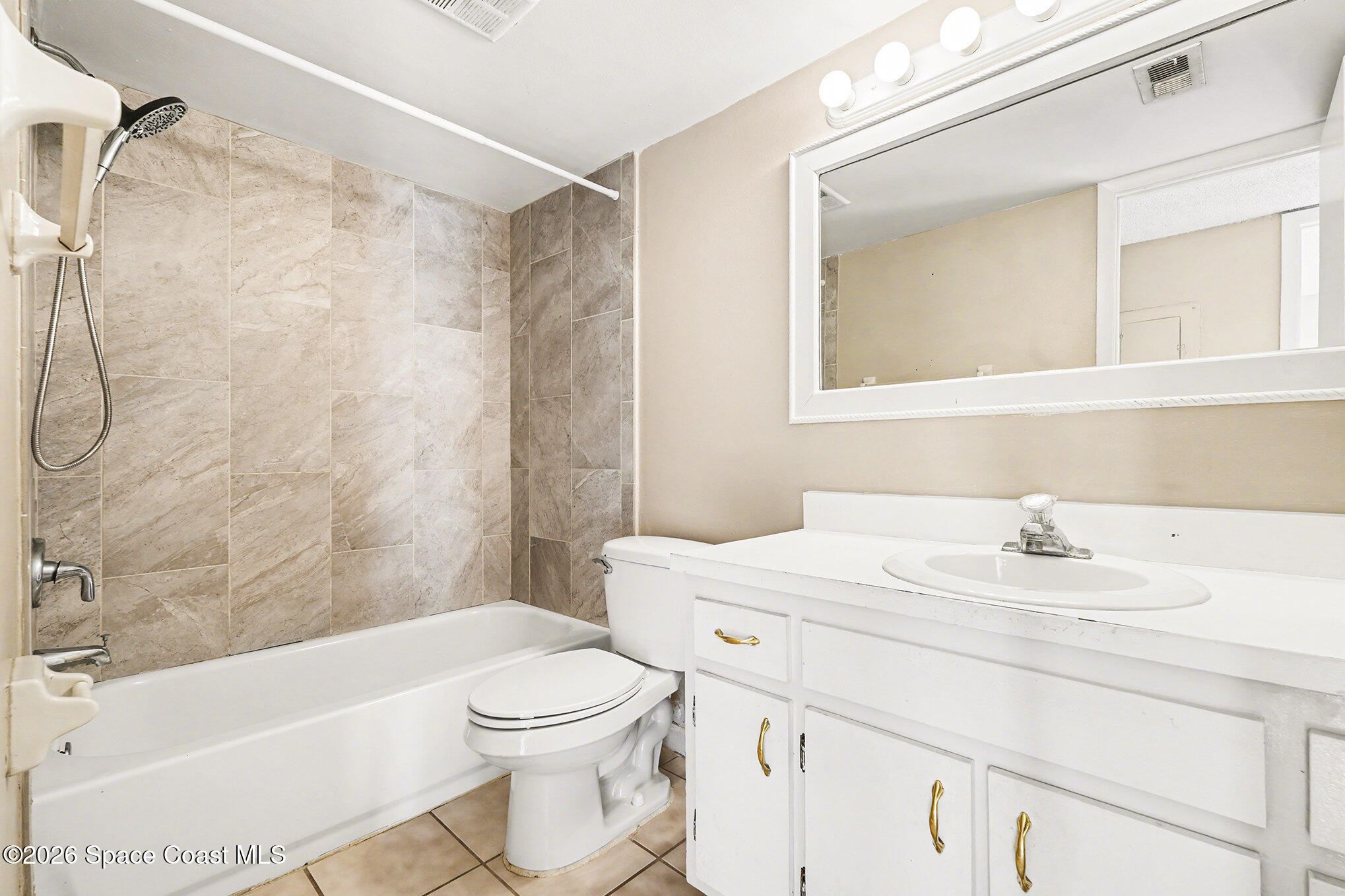 598 North Wickham Road, Unit 74 Melbourne, FL 32935 - Photo 9 of 13 a bathroom with a sink toilet vanity and shower