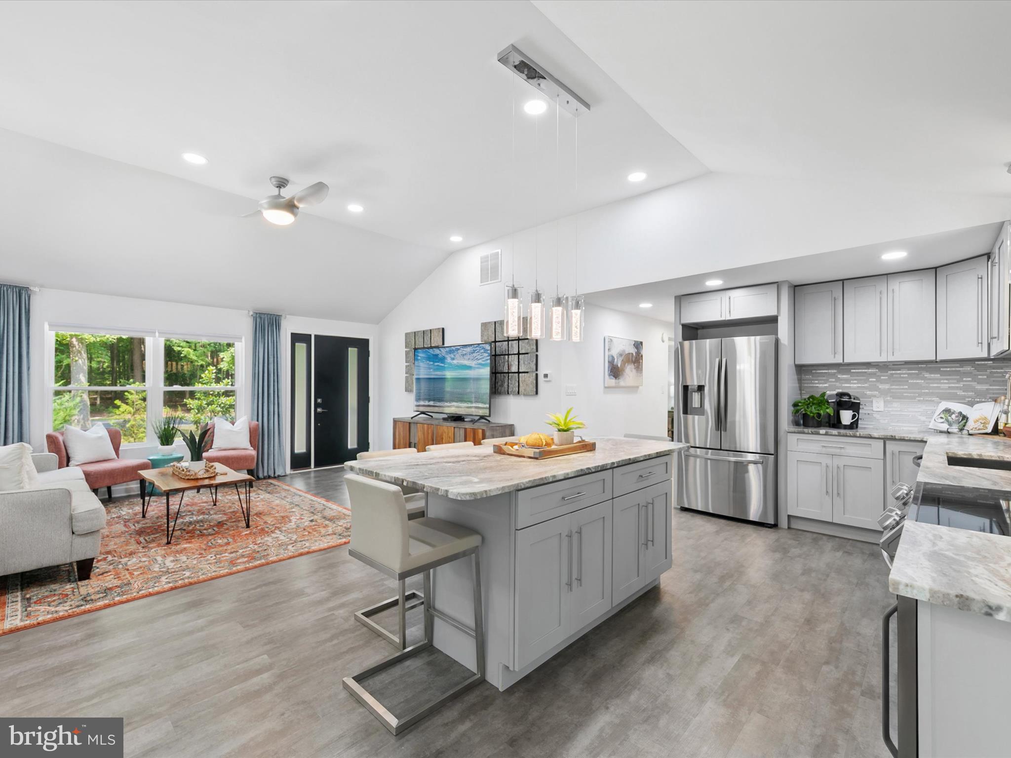 26076 Anderson Corner Road Georgetown, DE 19947 - Photo 11 of 36 a kitchen with stainless steel appliances a stove a refrigerator white cabinets and couches with wooden floor