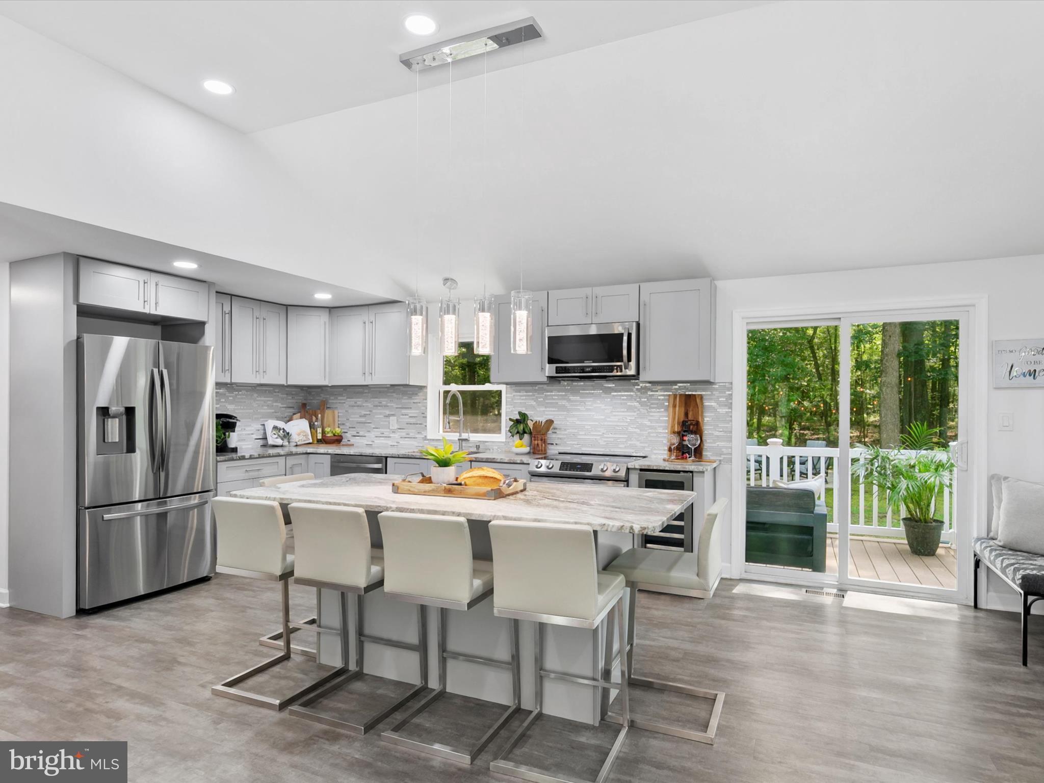 26076 Anderson Corner Road Georgetown, DE 19947 - Photo 8 of 36 a kitchen with stainless steel appliances a stove a refrigerator a sink a stove a dining table and chairs