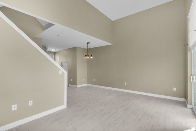 14108 Pepi Band Road Draper, UT 84020 - Photo 9 of 36 Spacious interior featuring a high vaulted ceiling, light wood-finish flooring, sliding glass patio doors, and an open staircase