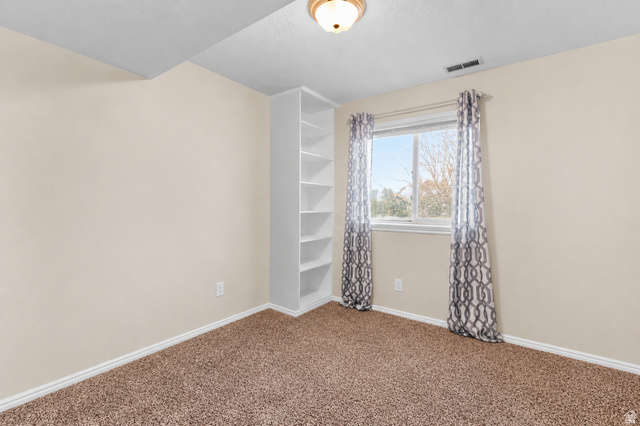 5727 South 3550th Street West Roy, UT 84067 - Photo 29 of 49 Bedroom featuring neutral wall paint, built-in shelving, and a window with natural light