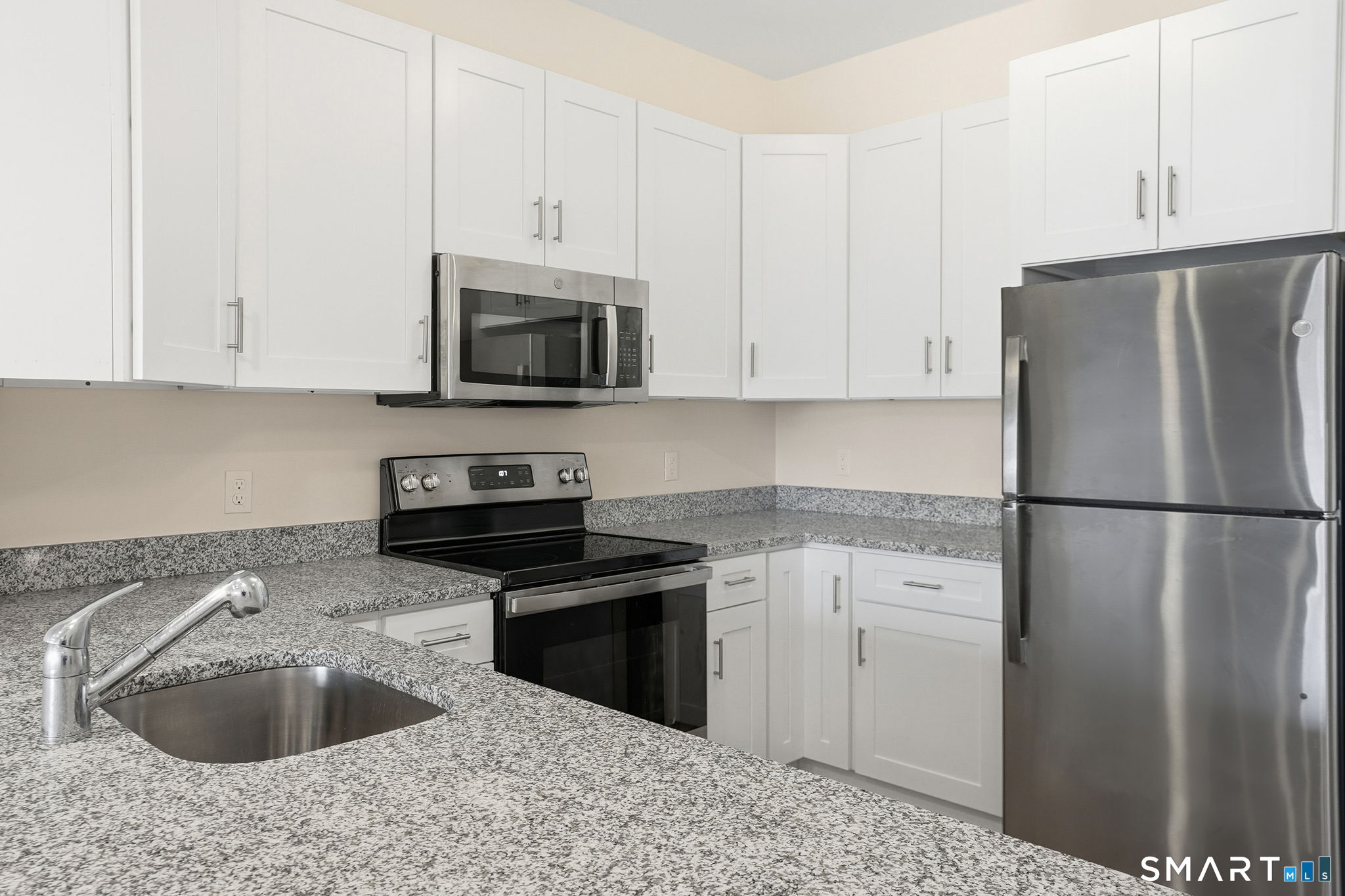 71 Connecticut Avenue, Unit 206 Norwalk, CT 06850 - Photo 10 of 17 a kitchen with granite countertop a refrigerator sink and stove
