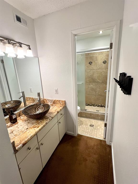 4845 Cedar Springs Road, Unit 368 Dallas, TX 75219 - Photo 20 of 38 a bathroom with a granite countertop sink and a mirror