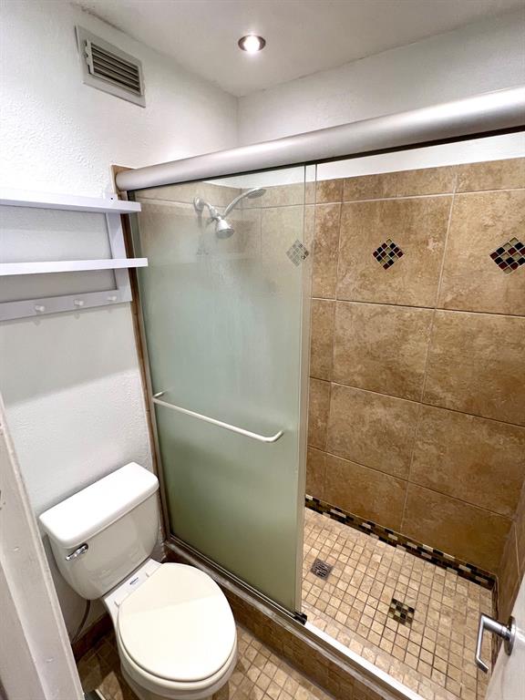 4845 Cedar Springs Road, Unit 368 Dallas, TX 75219 - Photo 21 of 38 a white toilet sitting next to a shower
