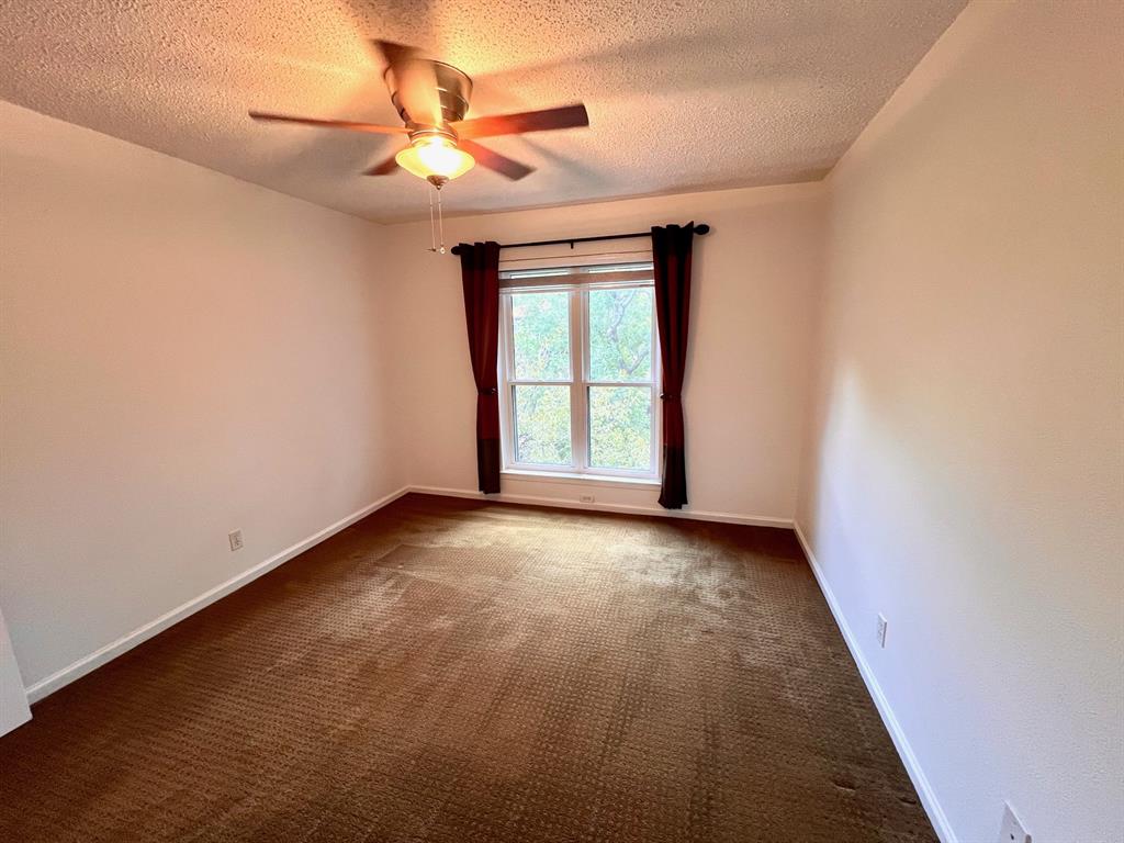 4845 Cedar Springs Road, Unit 368 Dallas, TX 75219 - Photo 26 of 38 an empty room with a window and a ceiling fan