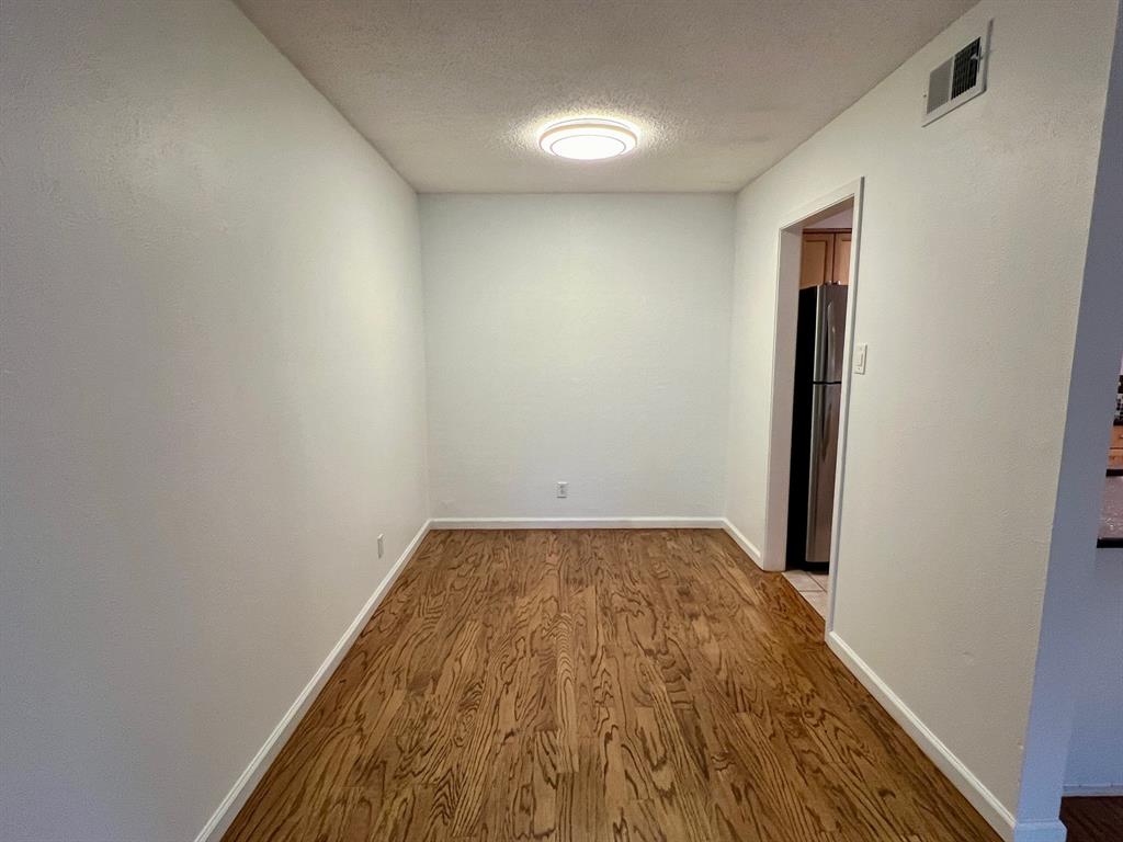 4845 Cedar Springs Road, Unit 368 Dallas, TX 75219 - Photo 9 of 38 an empty room with wooden floor and entrance
