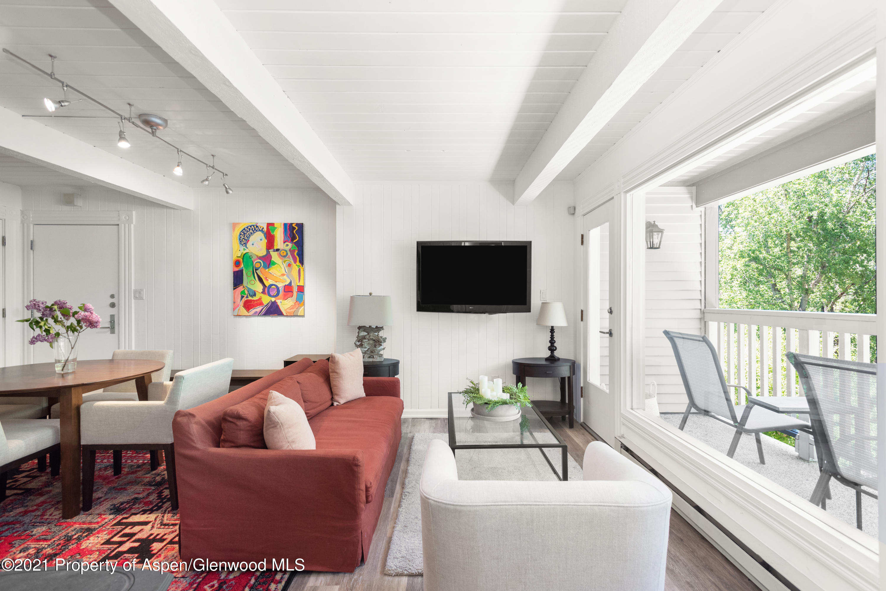 a living room with furniture a flat screen tv and a floor to ceiling window