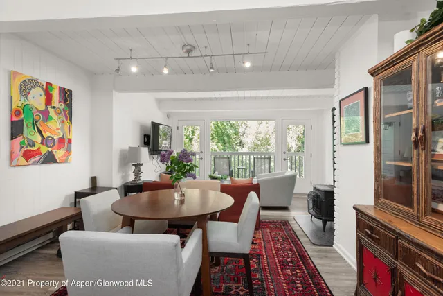 a view of a dining room with furniture a rug and wooden floor