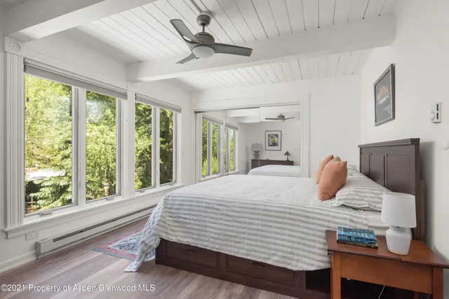 a bedroom with a large bed and wooden floor